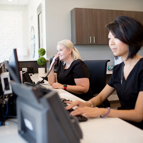 Front desk staff at Night and Day Dental working and processing insurance information.
